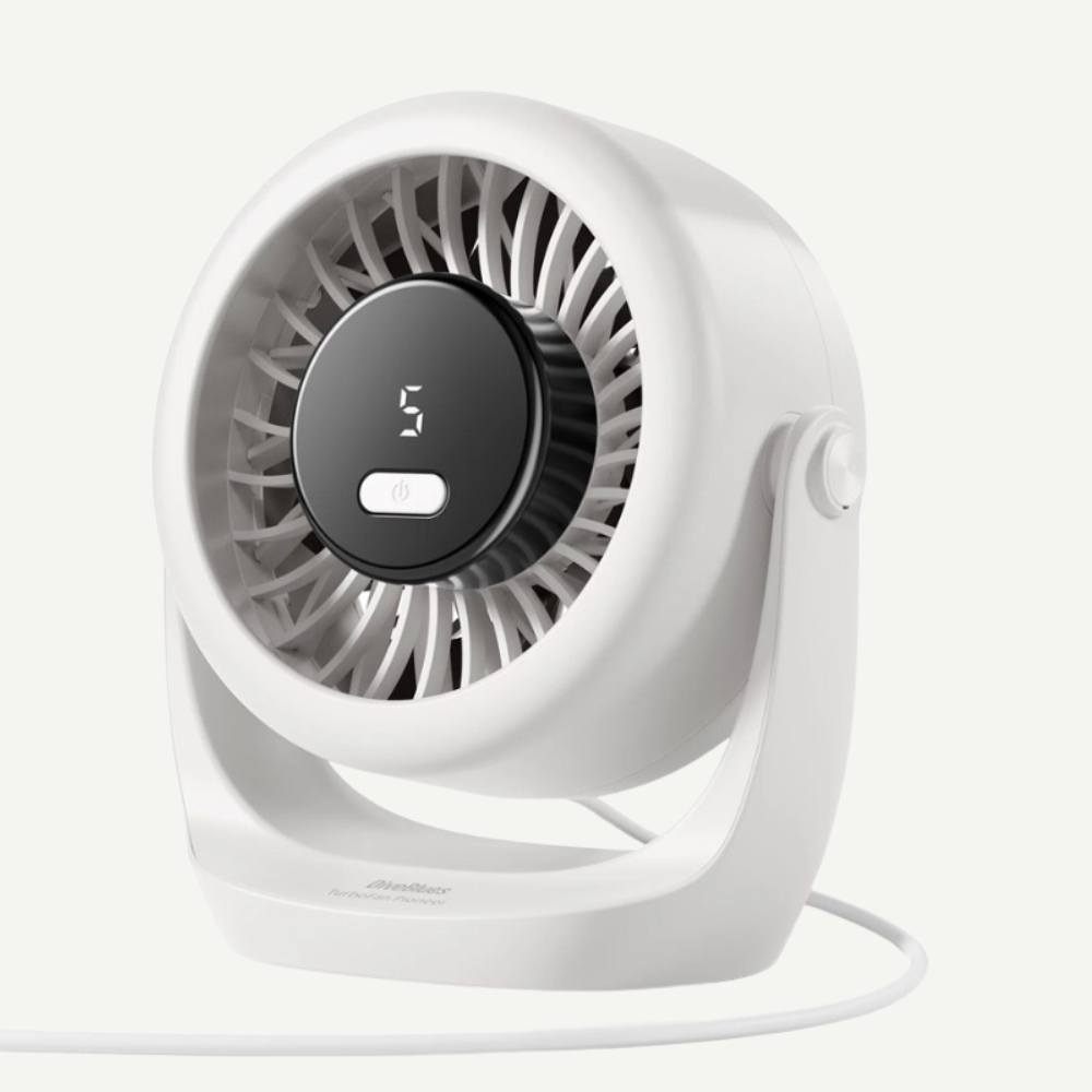 A compact white desk fan with a circular black control panel displaying '3' and a white cord, photographed on a clean off-white background.