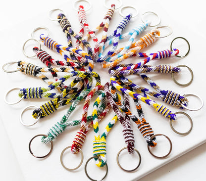 Colorful braided keychains arranged in a circular pattern on a white surface.