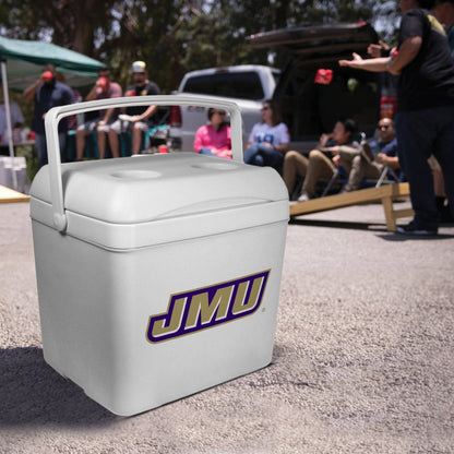 A white JMU cooler with a handle and a large JMU logo on the front, photographed outdoors at a social event with people and vehicles blurred in the background.