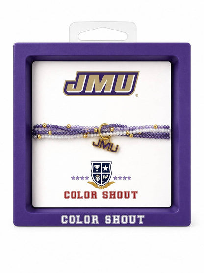 A JMU 'Color Shout' beaded bracelet displayed inside its purple retail packaging. The bracelet features purple and white beads with small gold accents, including a gold 'JMU' charm.