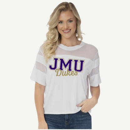 Woman wearing a white t-shirt with 'JMU Dukes' text on a plain background